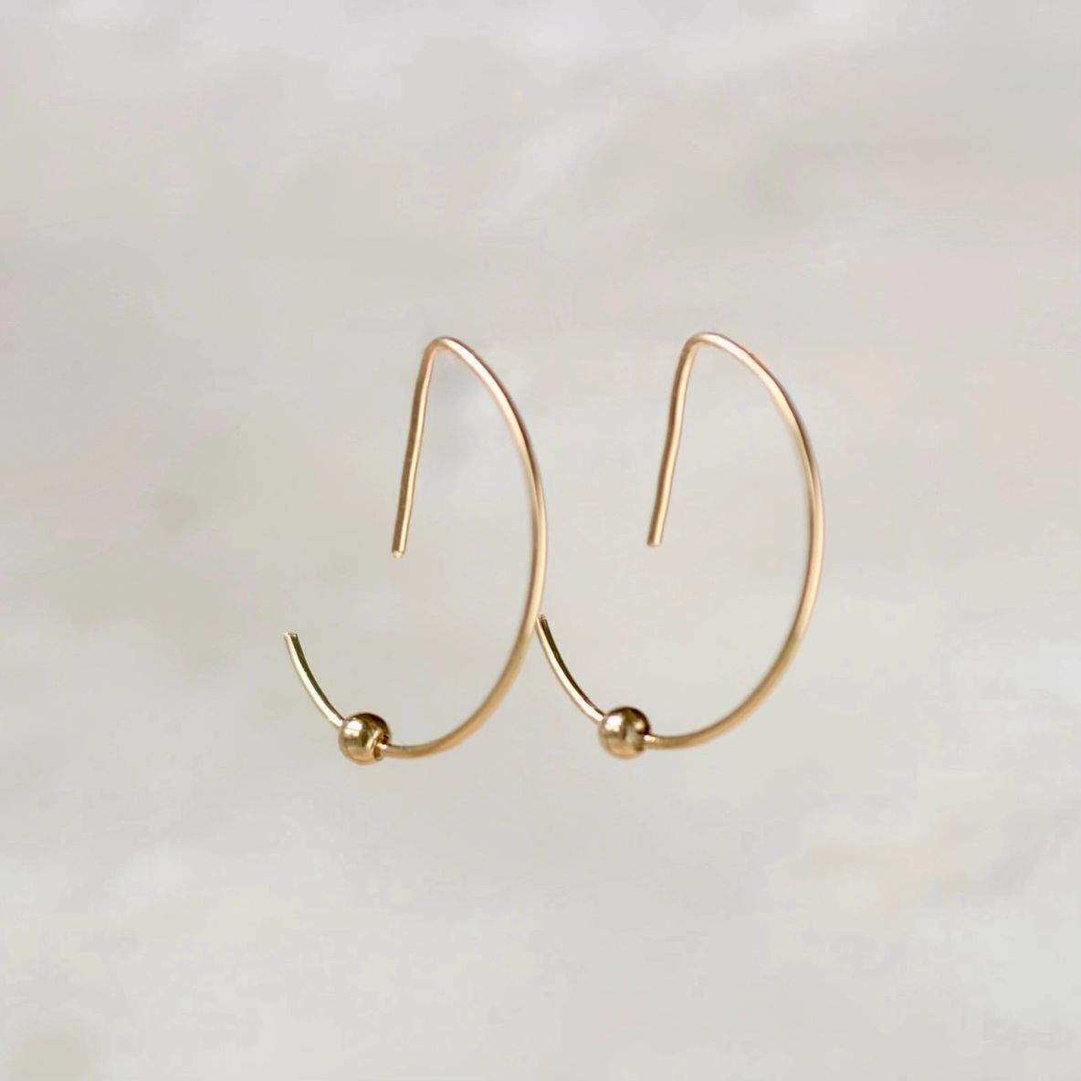Gold hoop earrings on white background.
